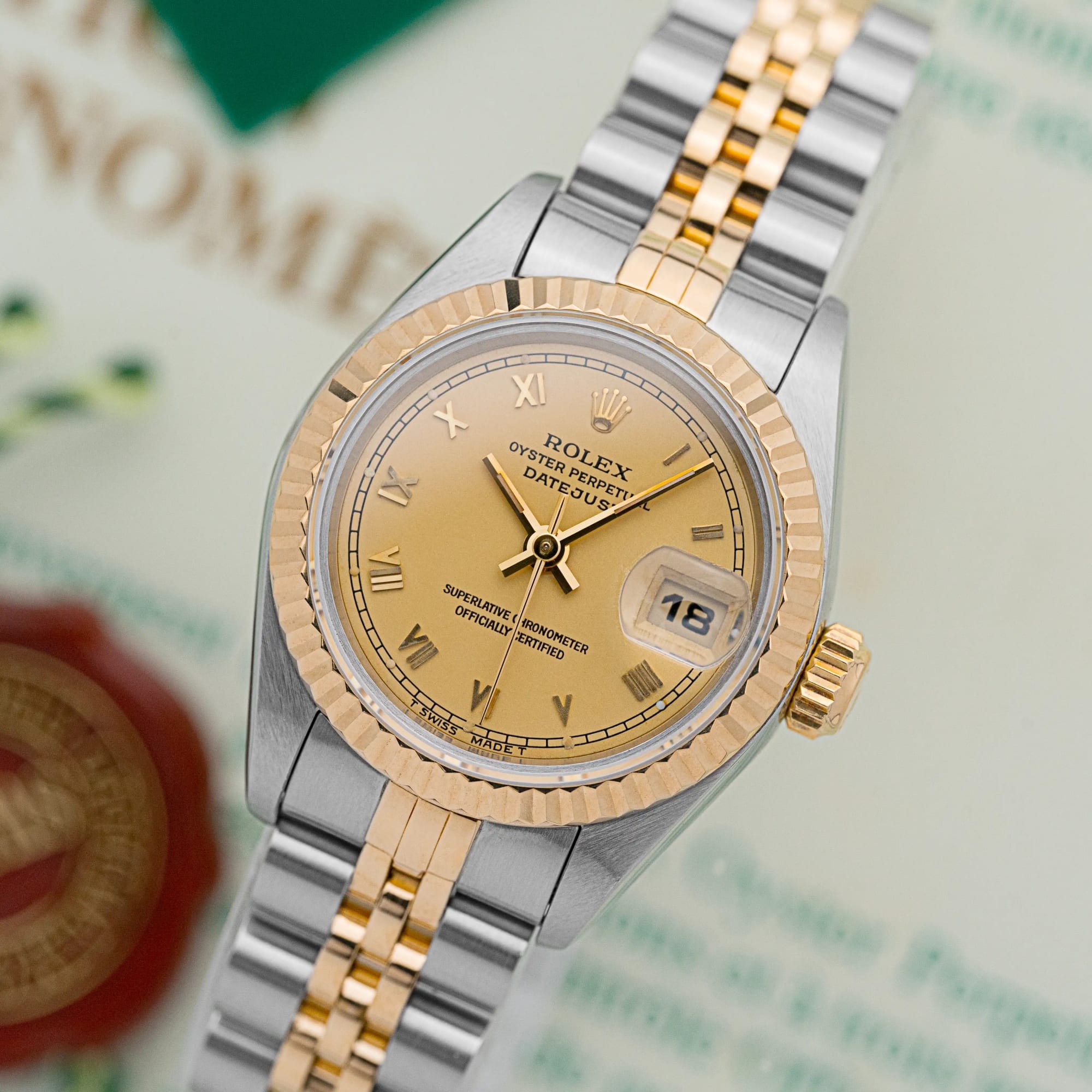 Rolex Lady-Datejust 69173 at an angle, showing champagne Roman dial, fluted gold bezel, and steel-and-gold Jubilee bracelet.