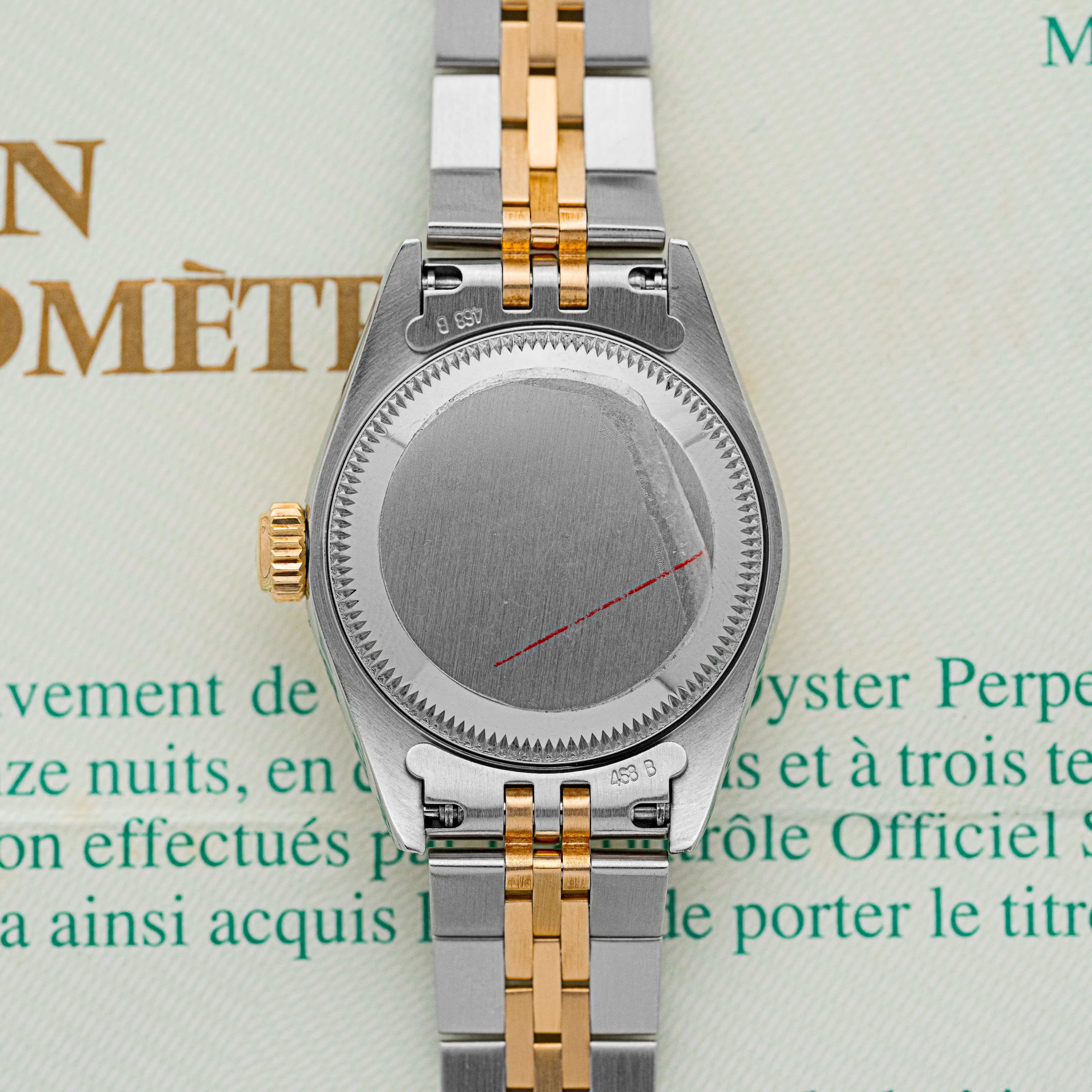 Steel caseback of the Rolex Lady-Datejust 69173 with red engraving line, two-tone bracelet attached.